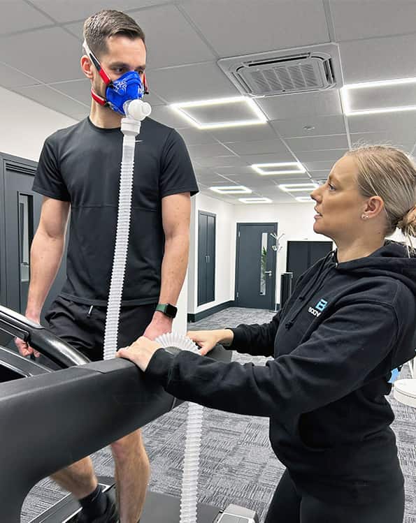 A customer receiving advice before starting a vo2 max test on a treadmill