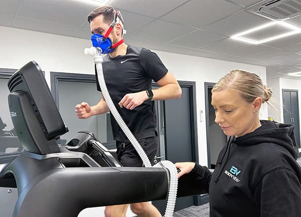 A customer running on a treadmill in a face mask during a vo2 max test