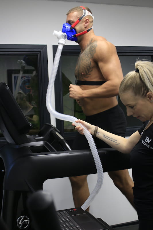 A customer receiving advice before starting a vo2 max test on a treadmill