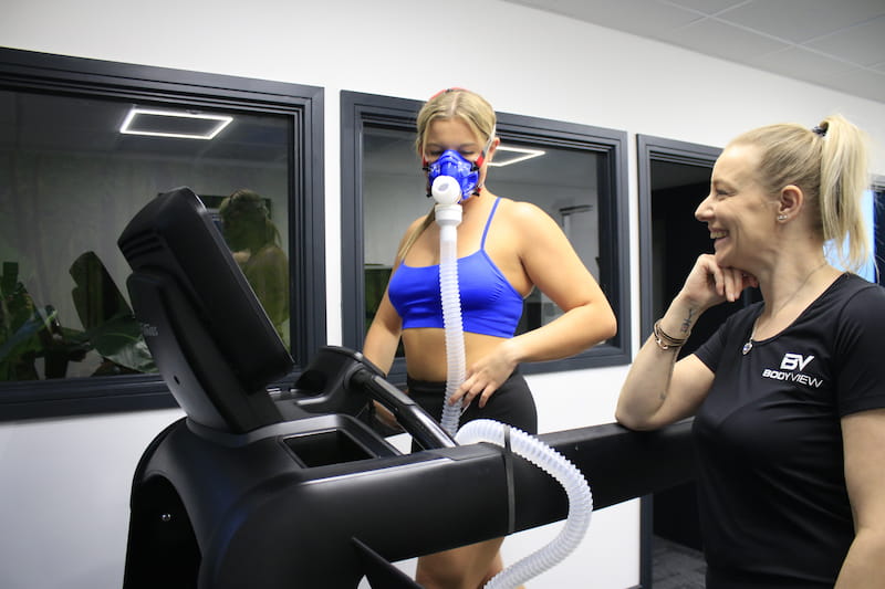 A customer running on a treadmill in a face mask during a vo2 max test